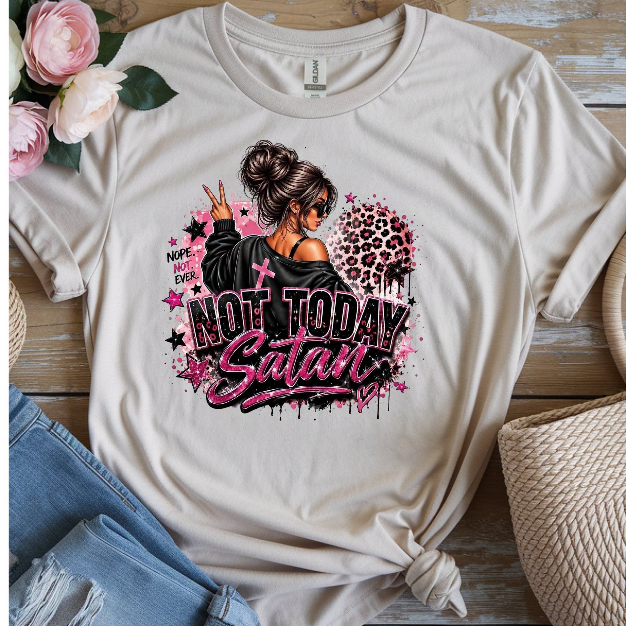 Sand colored t-shirt with graphic of a girl with messy bun and sunglasses, cross, leopard print heart, and bold text reading Not Today Satan with Nope Not Ever